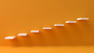 white steps rising on orange wall