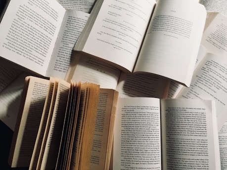 Stack of open books showing different page layouts and illustrations.