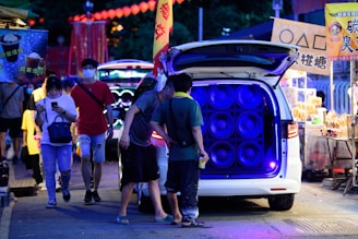 A vibrant mobile advertising truck with a stage setup and wireless microphones in Chiang Mai city.