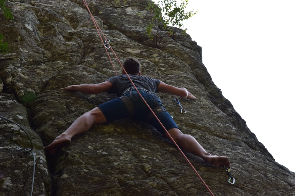 um homem escalando rocha