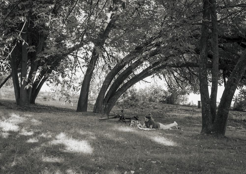 a person lying on the ground under a tree