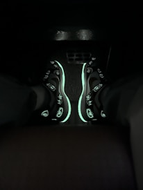 Close-up of colorful neon sneakers glowing under blacklight.