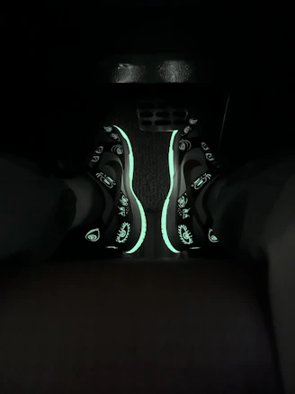 Close-up of a sleek black and neon-accented sneaker glowing softly against a dark background
