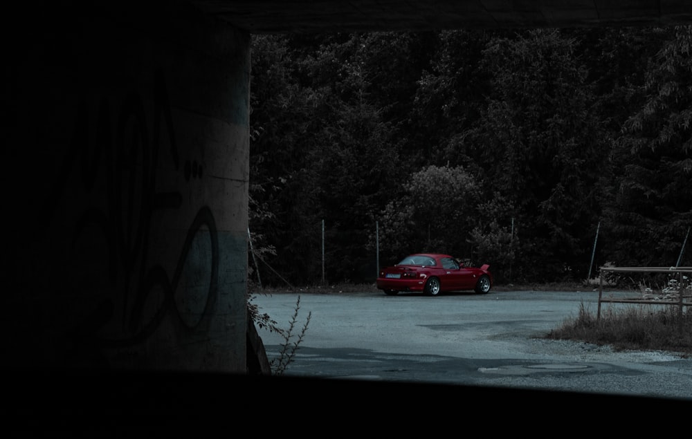 a red car driving on a road