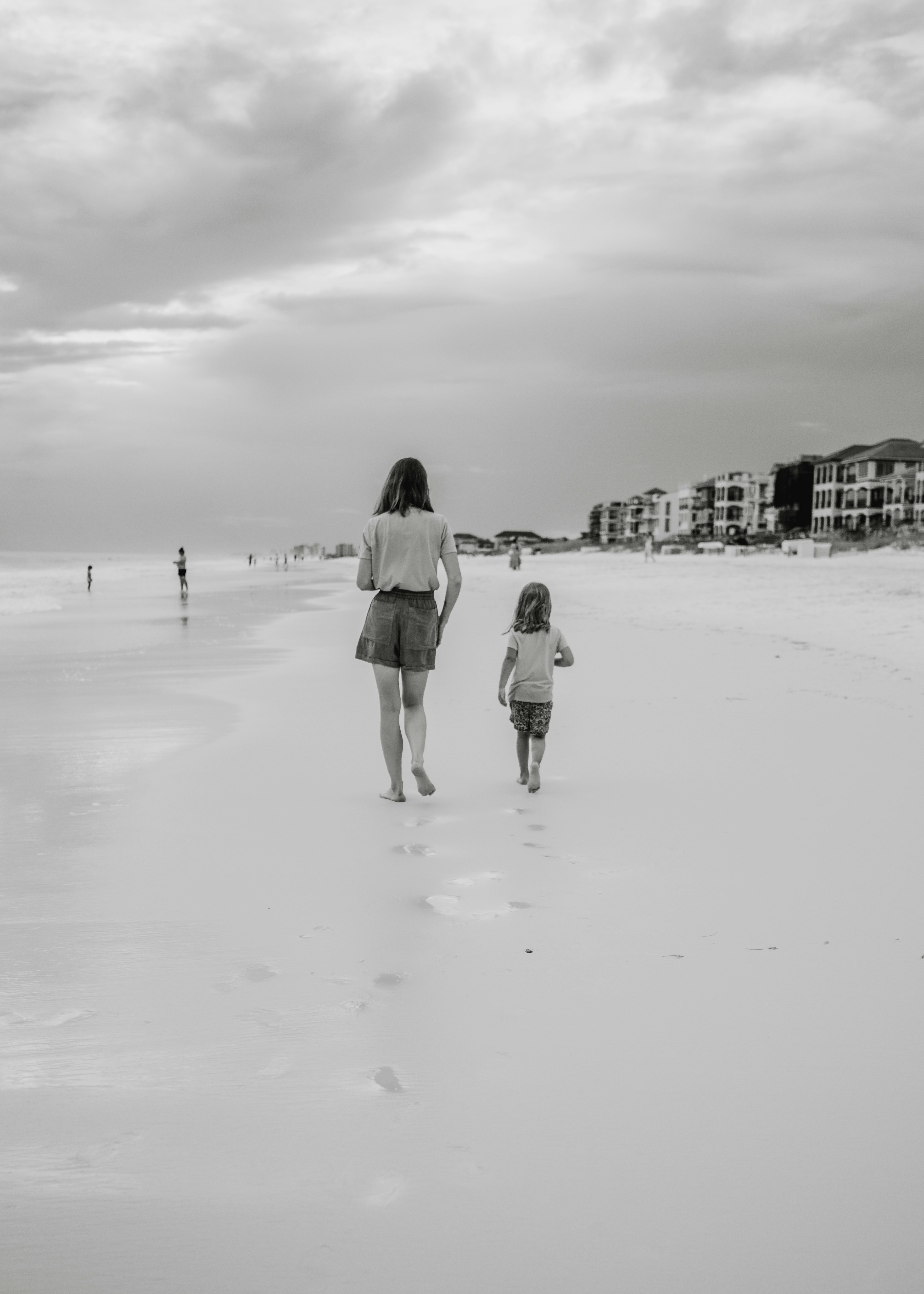 Una persona y un niño caminando en una playa