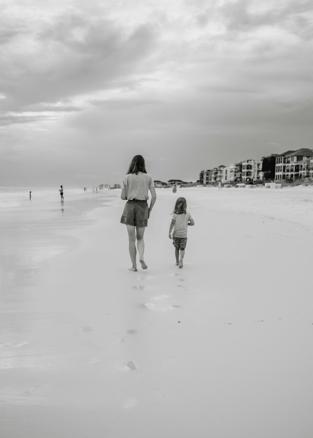 a person and a child walking on a beach