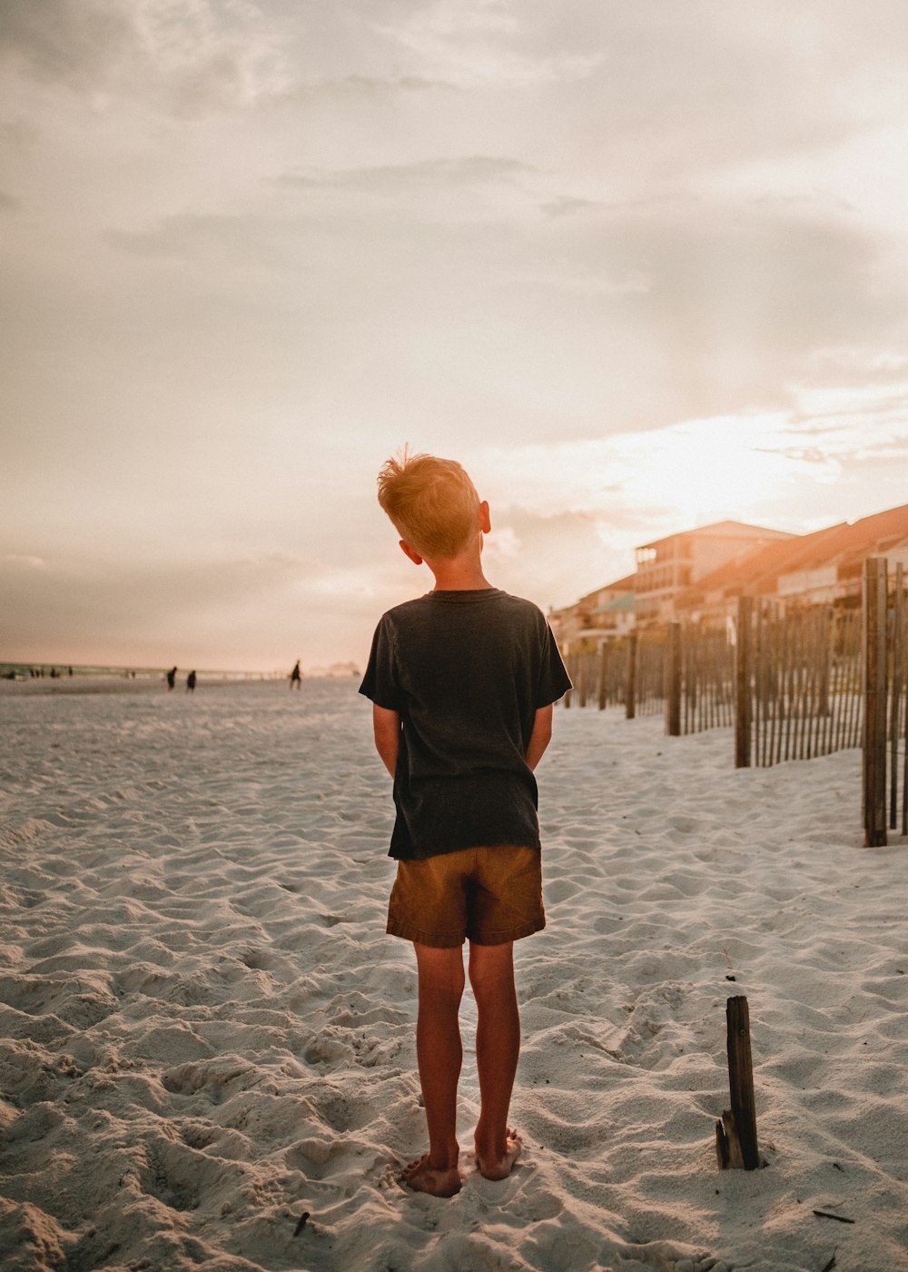 um menino em pé em uma praia