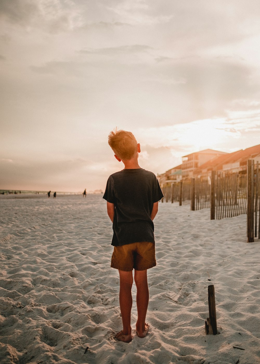 a boy standing on a beach