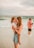 a person holding a baby on a beach