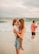 a person holding a baby on a beach