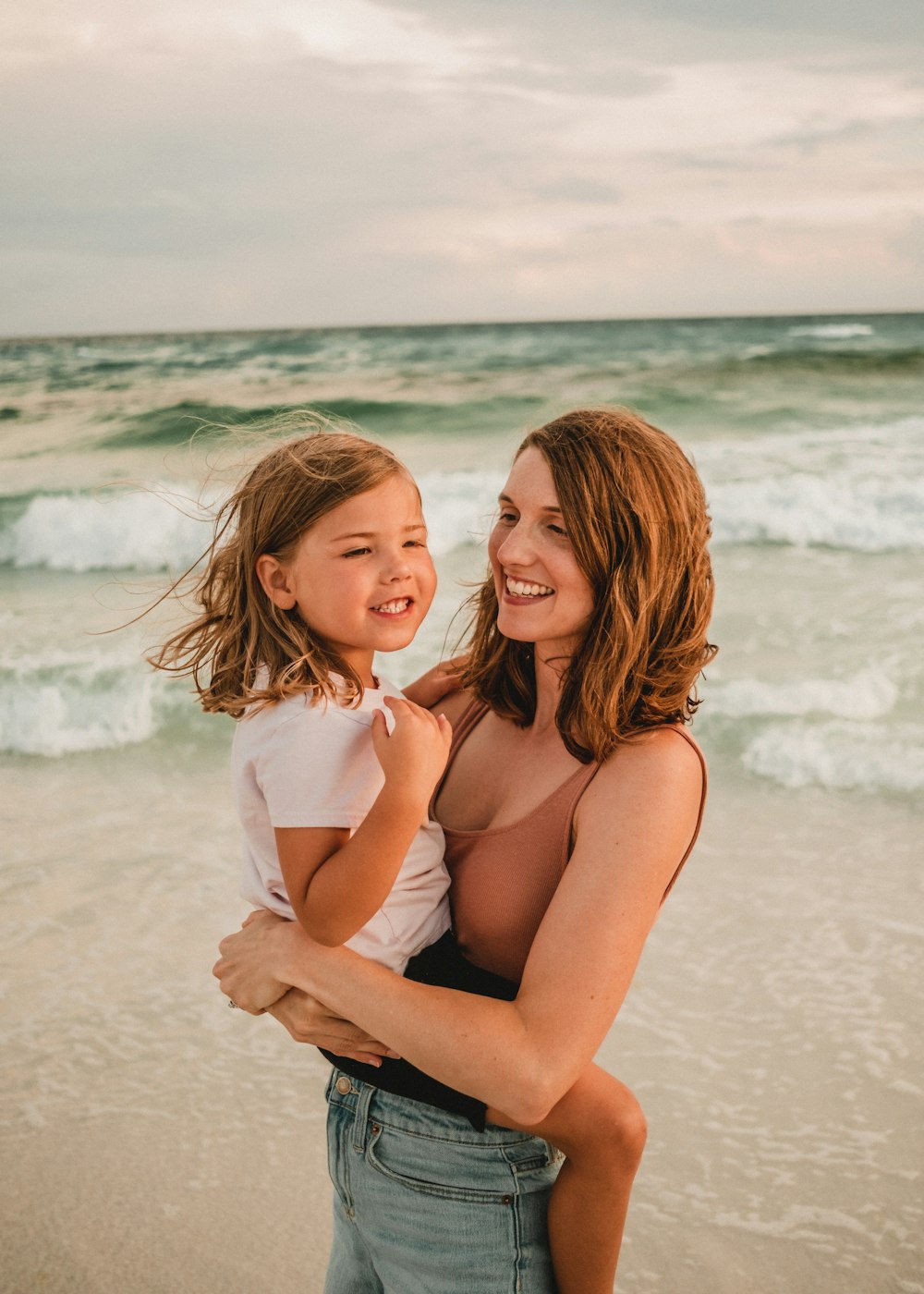 a person holding a child on a beach