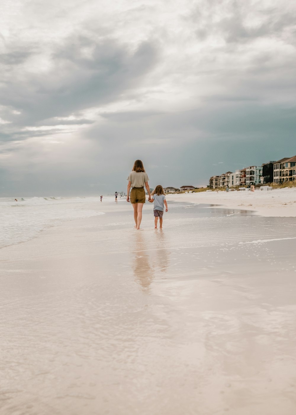 a person and a child walking on a beach