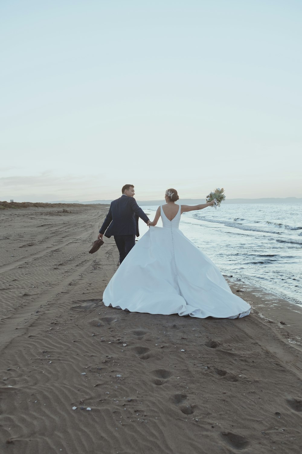 a man and woman holding hands on a beach