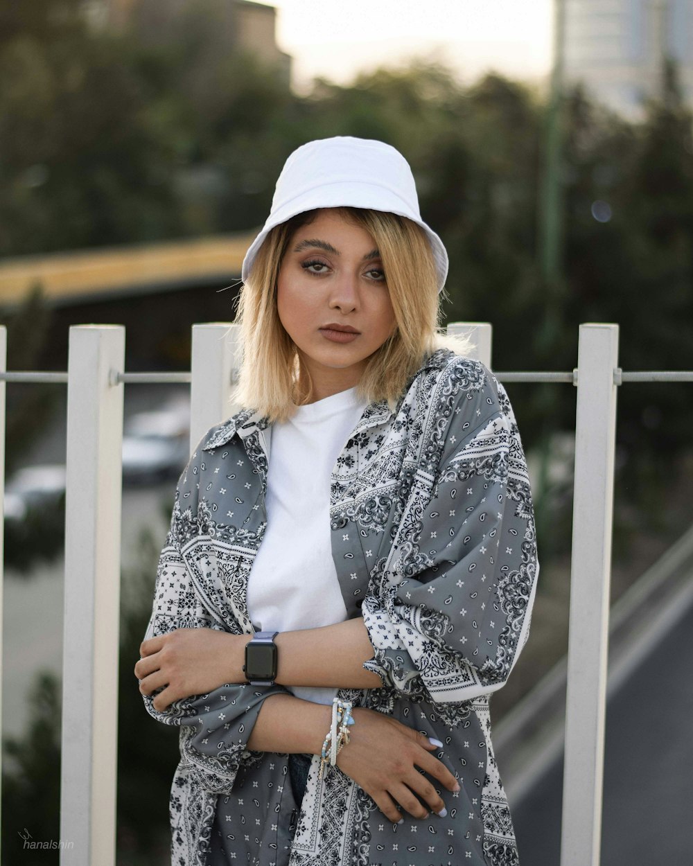 a person in a hat leaning on a white railing