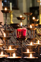A set of sleek, modern metal candle holders arranged on a wooden table with soft lighting.