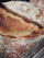 Close-up of a happy customer enjoying a fresh artisan sourdough bread in a cozy bakery setting.