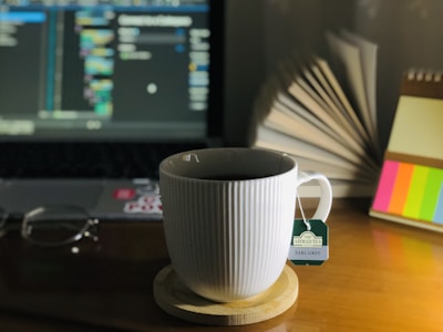 A desktop with English learning materials and a cup of tea in soft pastel colors.