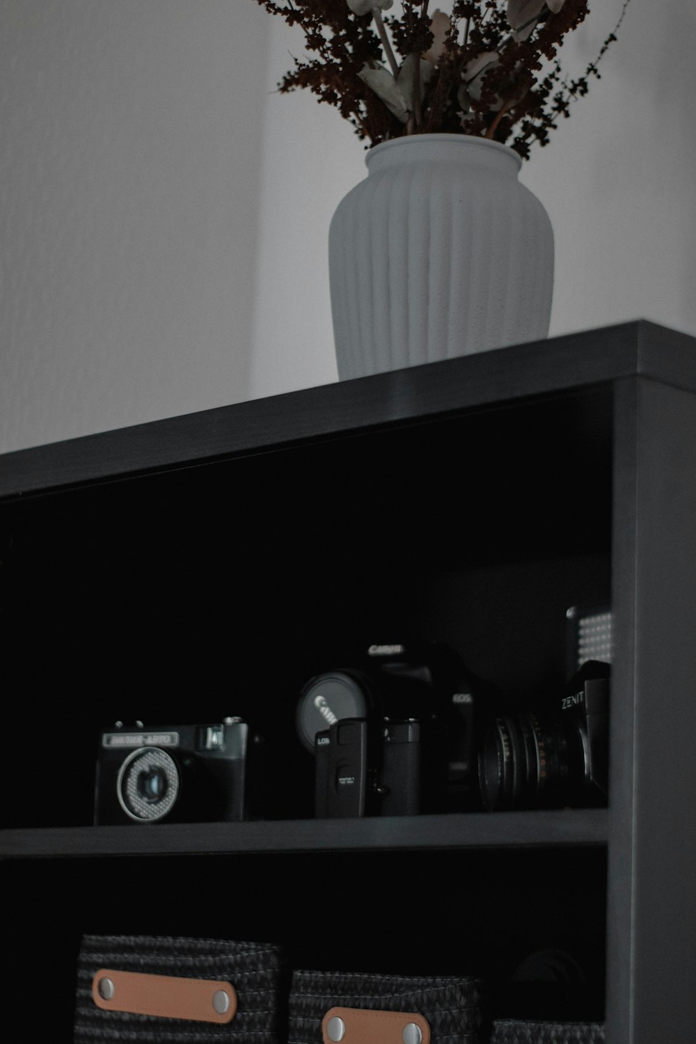 a vase with flowers on a shelf