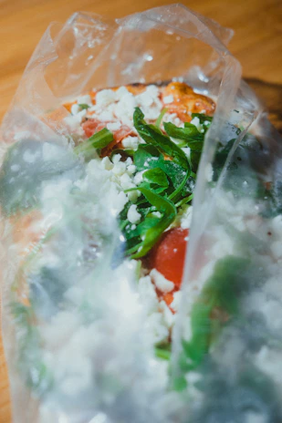 Close-up of biodegradable food packaging with fresh ingredients inside.