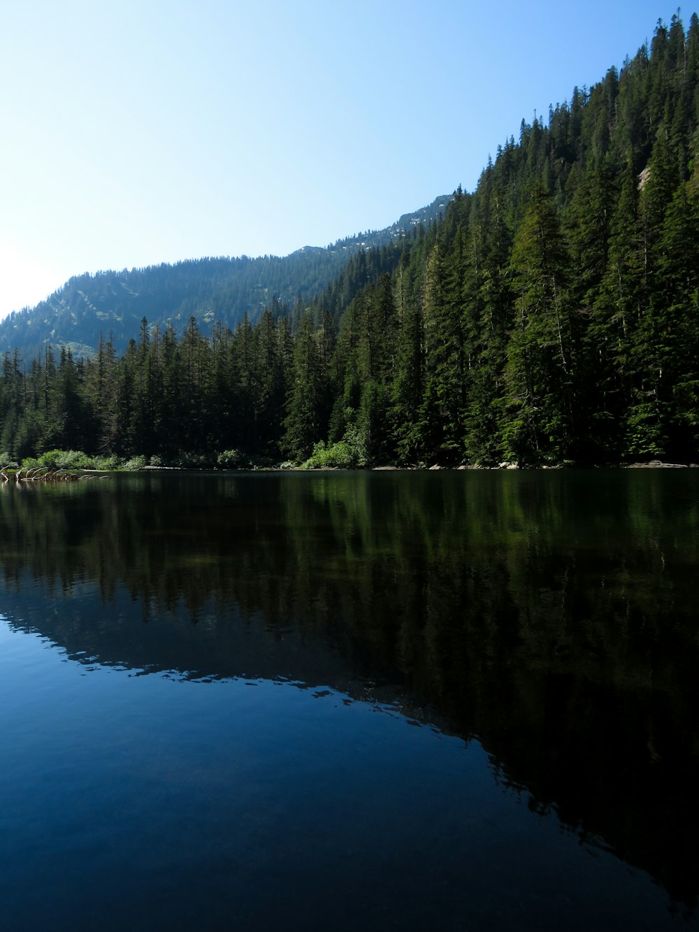 a lake with trees and mountains in the background