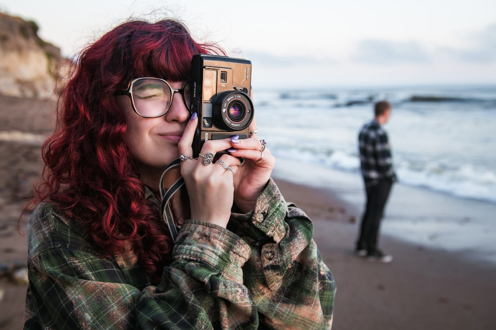 a person taking a picture with a camera on a beach