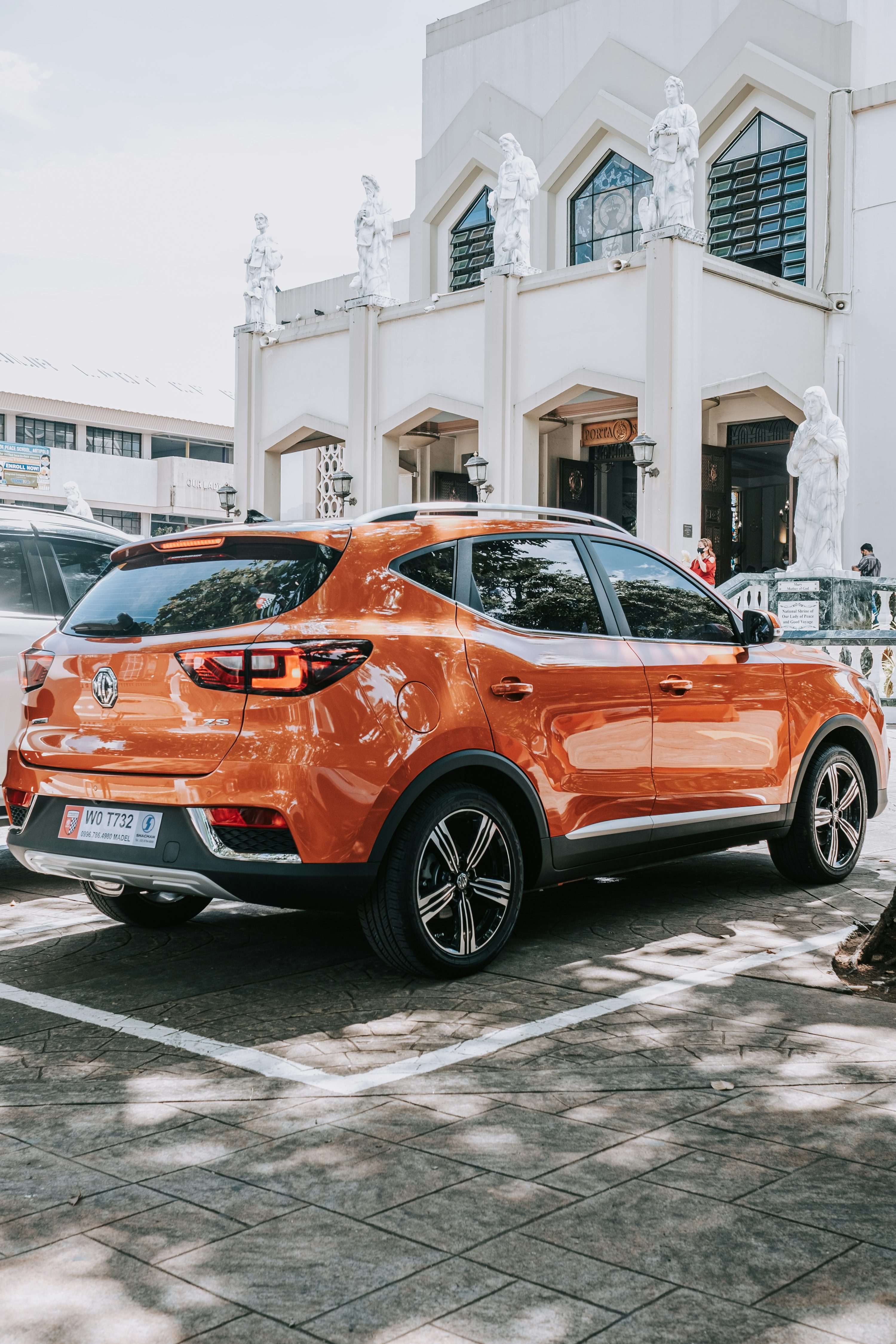 an orange car parked in front of a white building