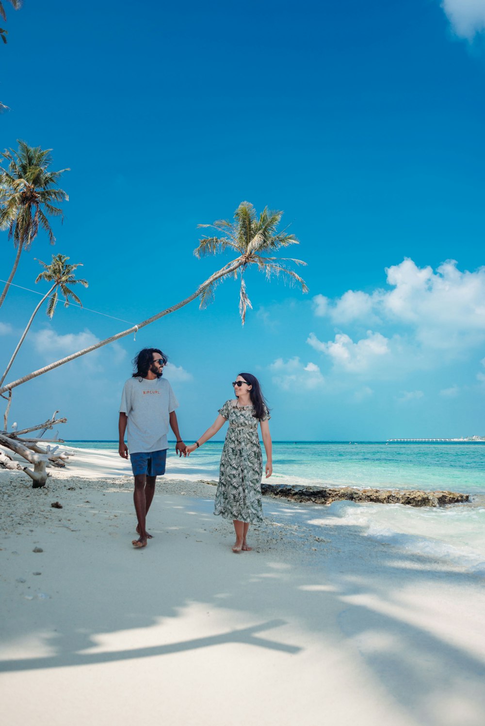 a man and woman walking on a beach