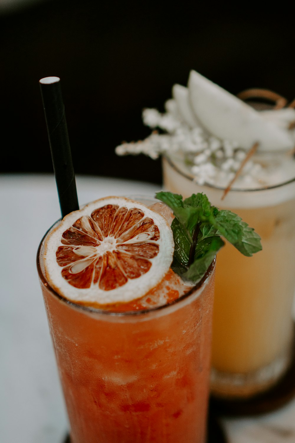 a glass with a drink in it and a straw