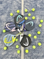 a pair of tennis rackets and balls on the ground
