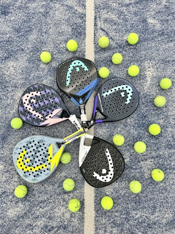 a pair of tennis rackets and balls on the ground