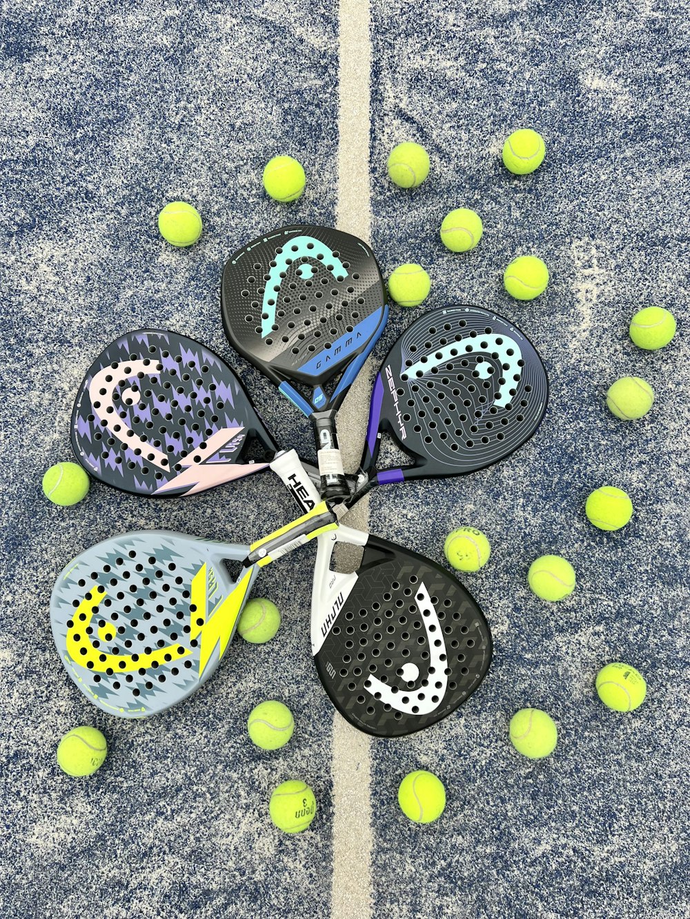 a pair of tennis rackets and balls on the ground