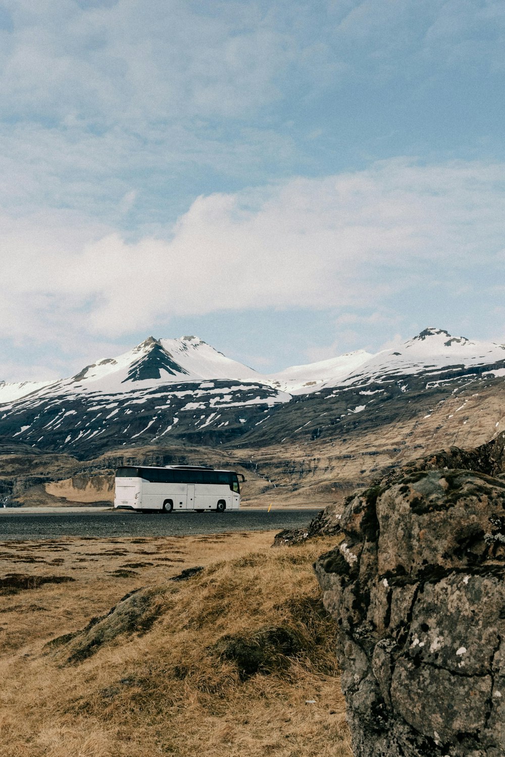 a white van parked on a road in front of a snowy mountain