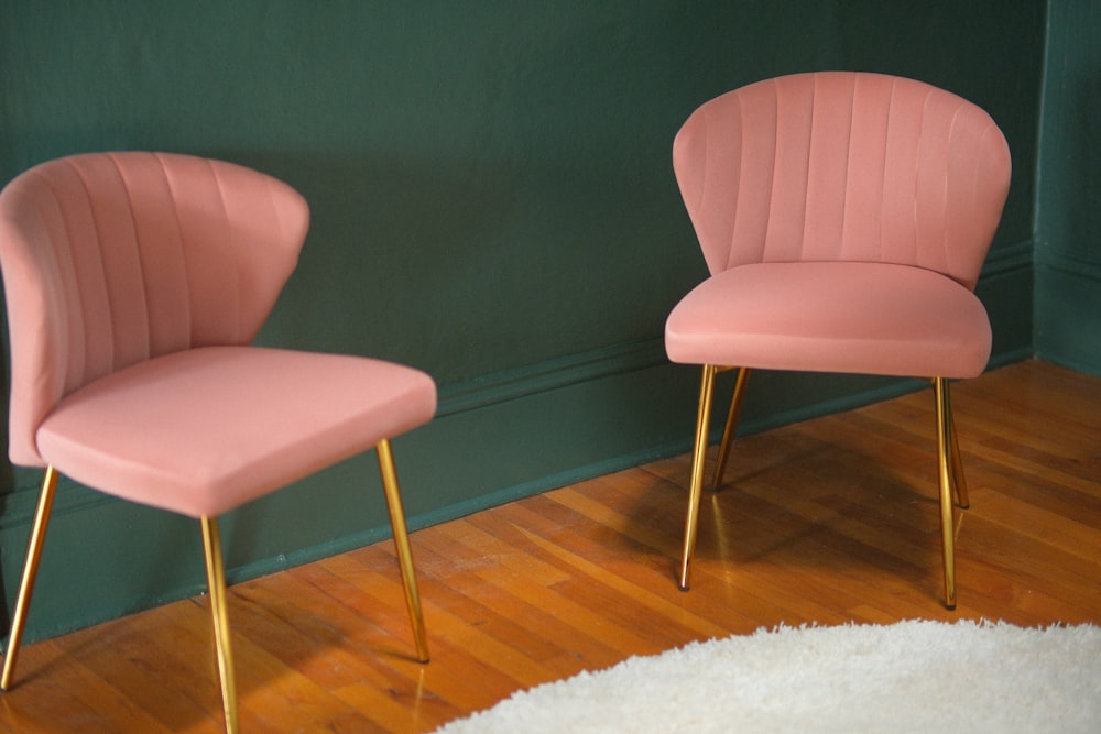 two pink chairs on a wood floor