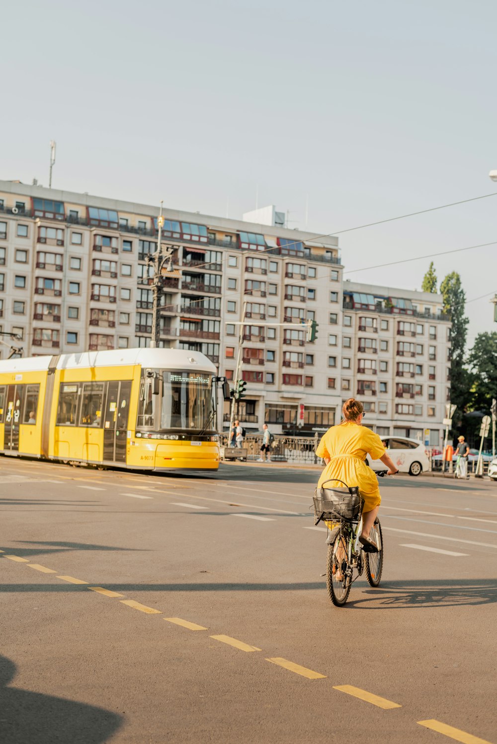 a person riding a bicycle next to a yellow bus