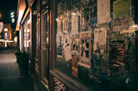 A quiet street corner with posters announcing a poetry reading event.