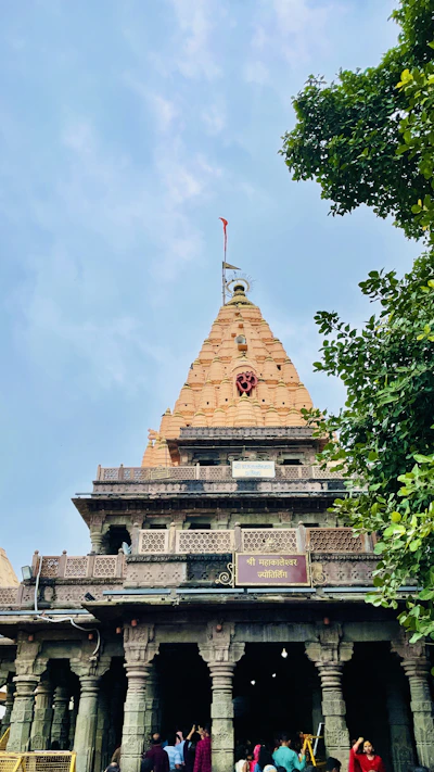 The Mahakaleshwar Jyotirlinga temple with its ornate tower against a blue sky in Ujjain.