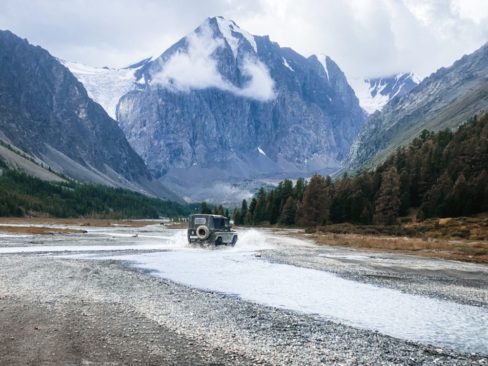 a truck driving on a road in front of mountains