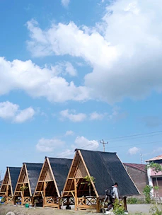 Row of modular labor hutments arranged neatly on a construction site under blue sky.