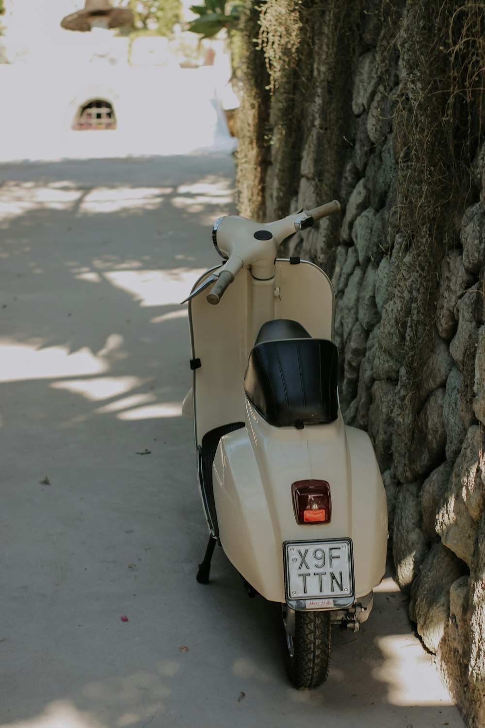 a scooter parked on a road next to a tree