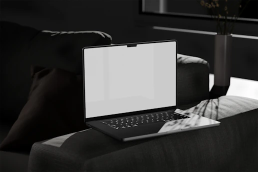 A sleek, minimalist laptop on a clean desk with green accent lighting symbolizing growth and money.
