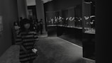Wide shot of visitors browsing elegant coin displays under soft lighting