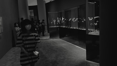 Wide shot of visitors browsing elegant coin displays under soft lighting