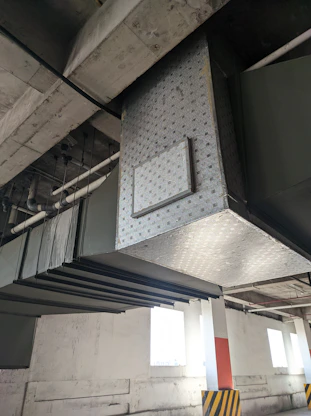 A friendly technician inspecting air ducts with cleaning equipment in a bright, modern home.