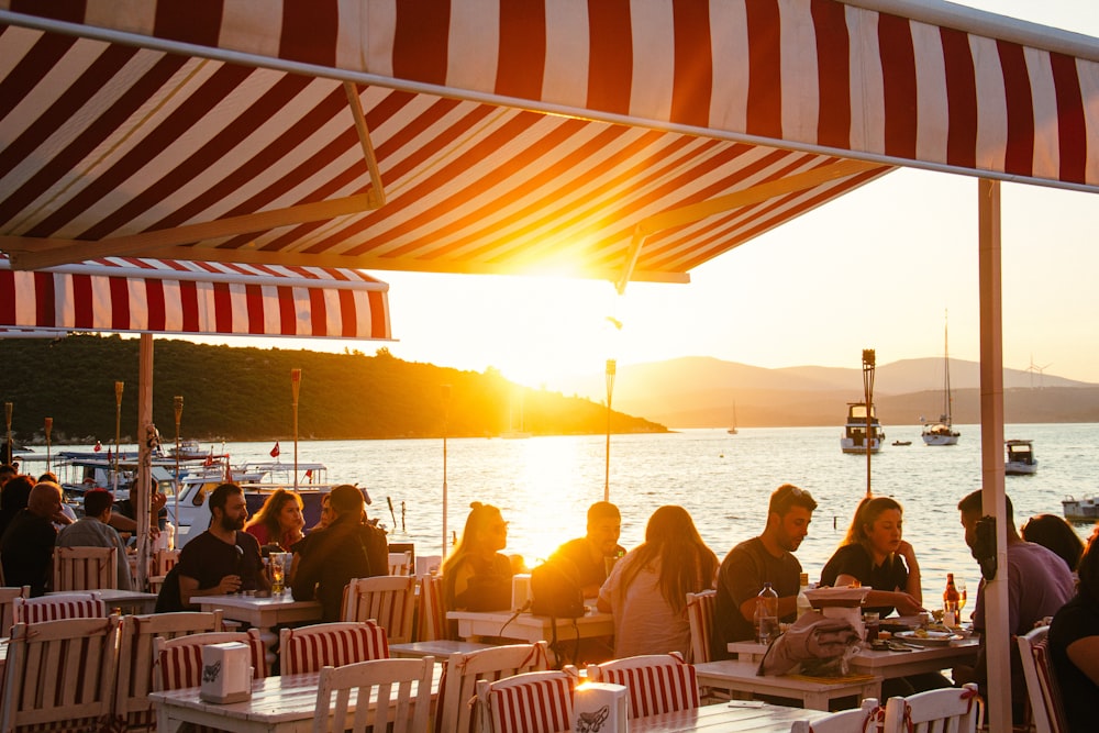 people sitting at tables under a tent