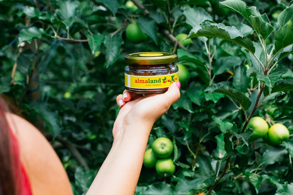 a person holding a jar of food