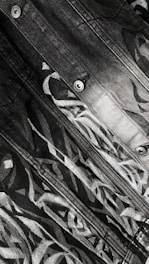 Close-up of a designer sketching detailed jean patterns on a drawing pad.