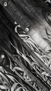 Close-up of a designer sketching detailed jean patterns on a drawing pad.