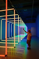 A student practicing neon flex bending in a bright workshop.