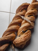 Vanilla cream-filled brioches displayed with a backdrop of wheat stalks.