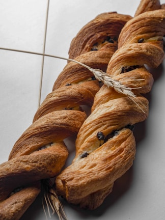 Vanilla cream-filled brioches displayed with a backdrop of wheat stalks.